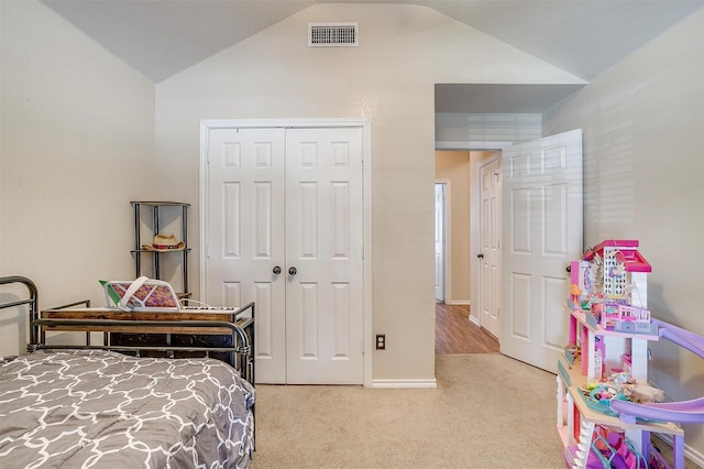 carpeted bedroom with lofted ceiling and a closet