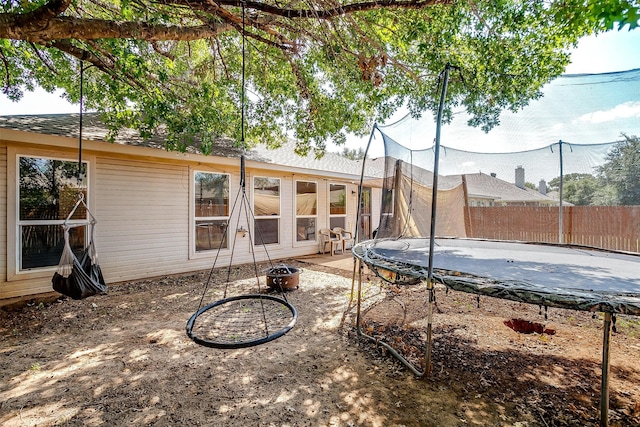 back of house with a trampoline