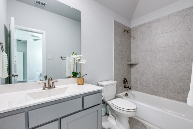 full bathroom with tile patterned floors, tiled shower / bath, vanity, and toilet