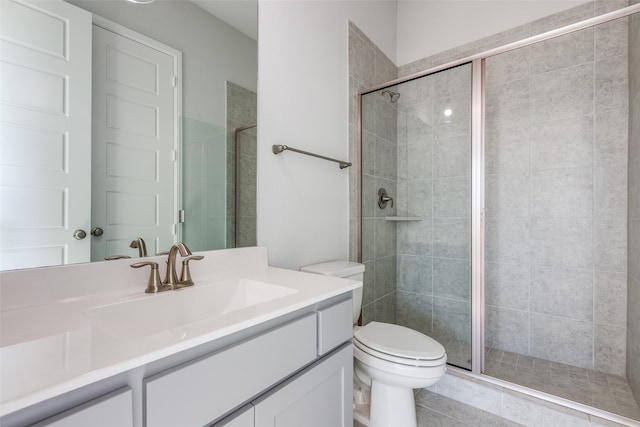 bathroom featuring tile patterned flooring, vanity, toilet, and an enclosed shower