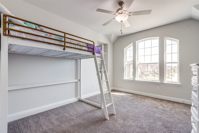 unfurnished bedroom featuring ceiling fan, carpet flooring, and vaulted ceiling