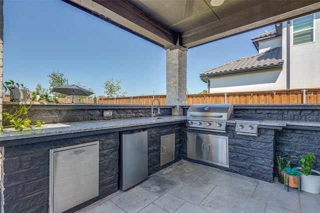 view of patio / terrace with an outdoor kitchen, a grill, and sink