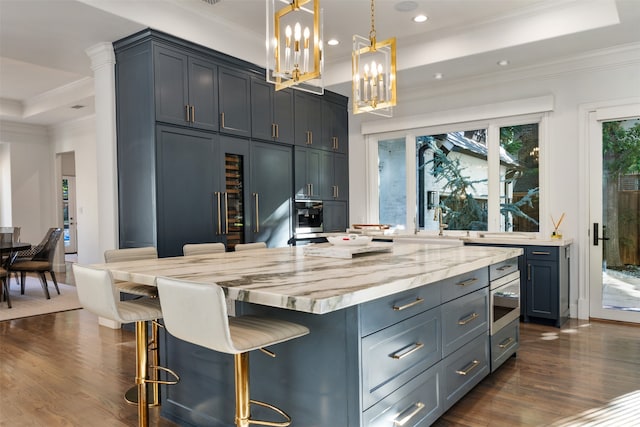 kitchen with a breakfast bar, crown molding, pendant lighting, dark hardwood / wood-style floors, and a kitchen island