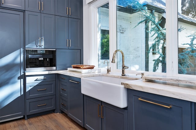 kitchen featuring wall oven, stainless steel refrigerator, sink, and dark wood-type flooring