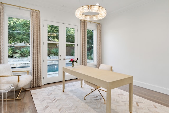 home office with plenty of natural light, light hardwood / wood-style floors, and french doors