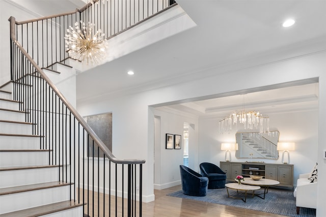 stairway featuring crown molding, a chandelier, and wood-type flooring