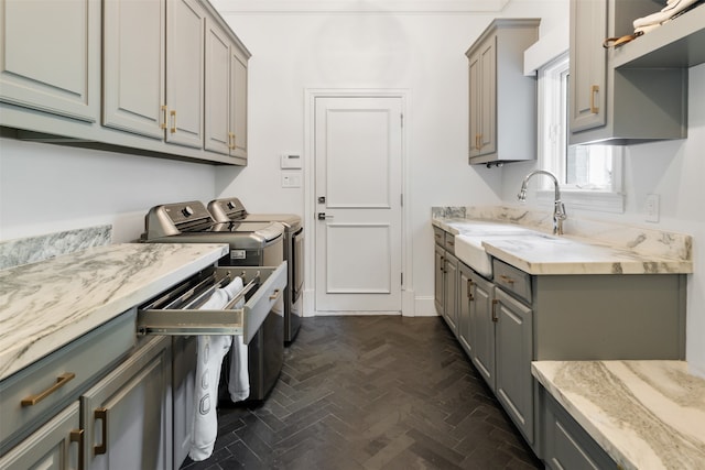 washroom with dark parquet flooring, separate washer and dryer, and sink