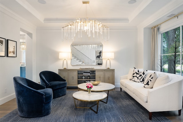 living room with a chandelier, ornamental molding, dark hardwood / wood-style floors, and a tray ceiling