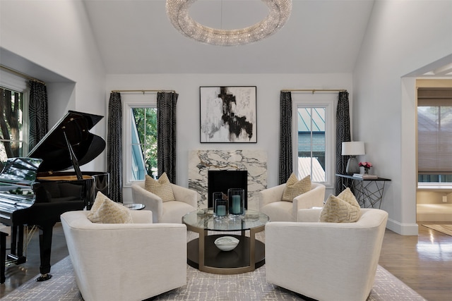 living room featuring a fireplace, wood-type flooring, a chandelier, and vaulted ceiling