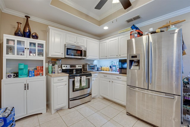 kitchen with ceiling fan, white cabinets, stainless steel appliances, and light tile patterned floors