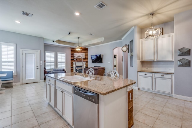 kitchen with stainless steel dishwasher, sink, a kitchen island with sink, and hanging light fixtures