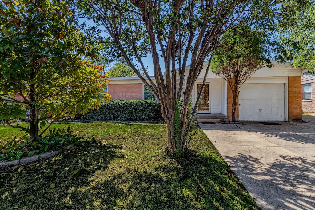 view of front of home with a front yard and a garage