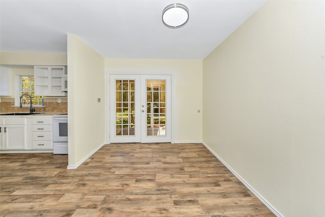 interior space with french doors, light wood-type flooring, and sink