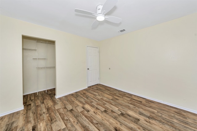 unfurnished bedroom featuring a closet, ceiling fan, and dark wood-type flooring