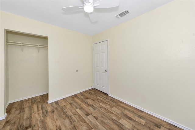 unfurnished bedroom with ceiling fan, a closet, and dark hardwood / wood-style flooring