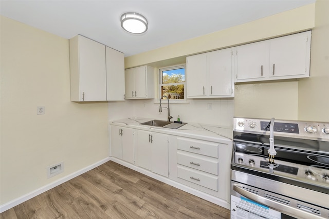 kitchen with light stone counters, light hardwood / wood-style floors, sink, white cabinets, and stainless steel electric stove