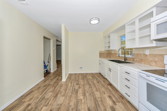 kitchen featuring light wood-type flooring, sink, white cabinets, white appliances, and light stone countertops