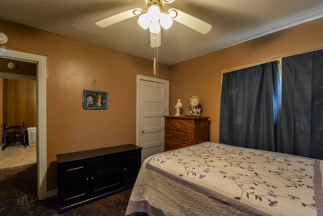 bedroom with a textured ceiling, dark carpet, and ceiling fan