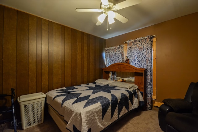 bedroom with ceiling fan, carpet floors, and wooden walls