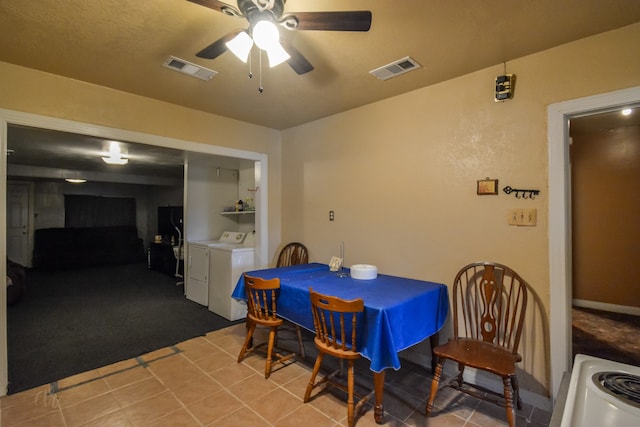 dining room featuring ceiling fan, separate washer and dryer, and light tile patterned floors