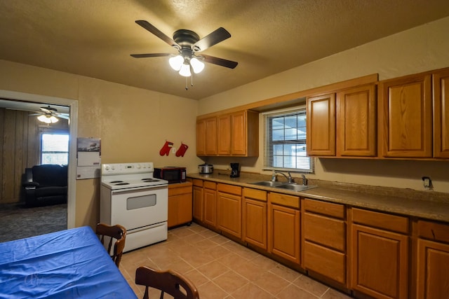 kitchen featuring a textured ceiling, sink, light tile patterned floors, white range with electric stovetop, and ceiling fan