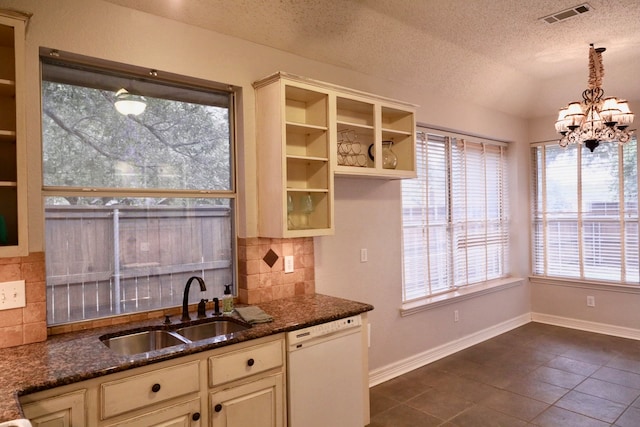 kitchen featuring dark stone countertops, a textured ceiling, decorative backsplash, and dishwasher