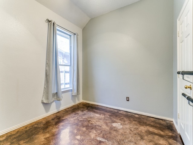 spare room featuring lofted ceiling and a textured ceiling