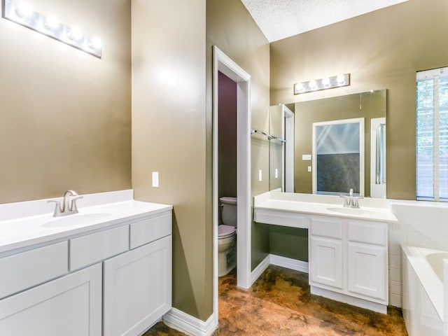 bathroom featuring toilet, a textured ceiling, vanity, and a bath