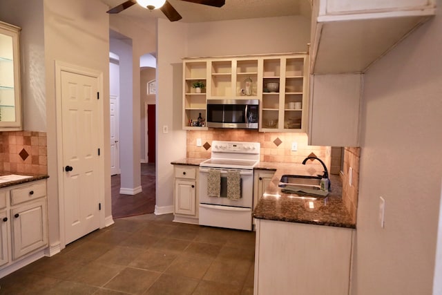 kitchen featuring electric range, ceiling fan, backsplash, dark tile patterned flooring, and sink