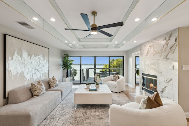 living room with light hardwood / wood-style flooring, ceiling fan, and a fireplace