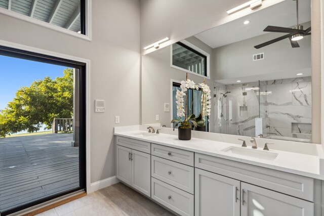 bathroom featuring vanity, a towering ceiling, ceiling fan, and an enclosed shower