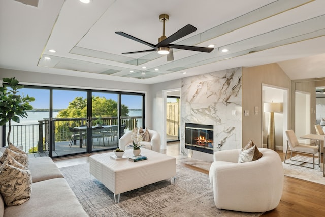 living room featuring lofted ceiling, a fireplace, hardwood / wood-style floors, and ceiling fan