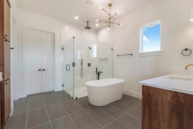 bathroom featuring plus walk in shower, a chandelier, tile patterned flooring, and vanity