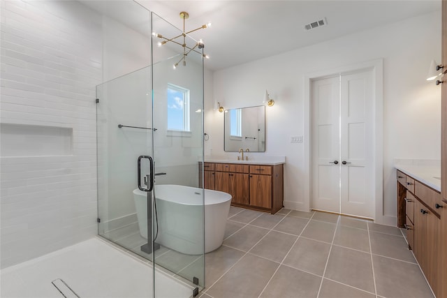 bathroom with an inviting chandelier, vanity, separate shower and tub, and tile patterned floors