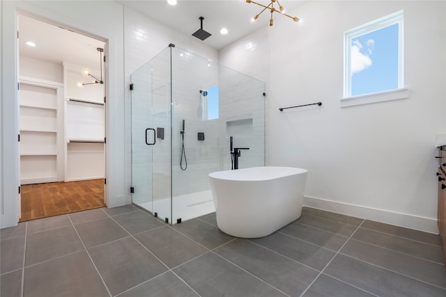 bathroom featuring an inviting chandelier, tile patterned flooring, vanity, and separate shower and tub