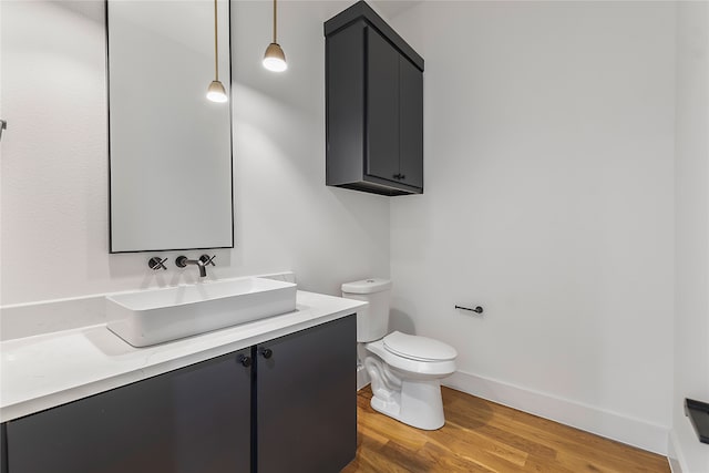 bathroom with hardwood / wood-style floors, vanity, and toilet