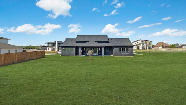 rear view of property featuring a lawn