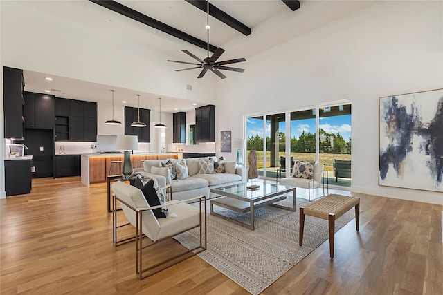 living room featuring ceiling fan, beamed ceiling, light hardwood / wood-style flooring, and high vaulted ceiling