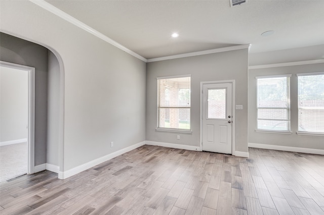 entryway with ornamental molding and light hardwood / wood-style floors