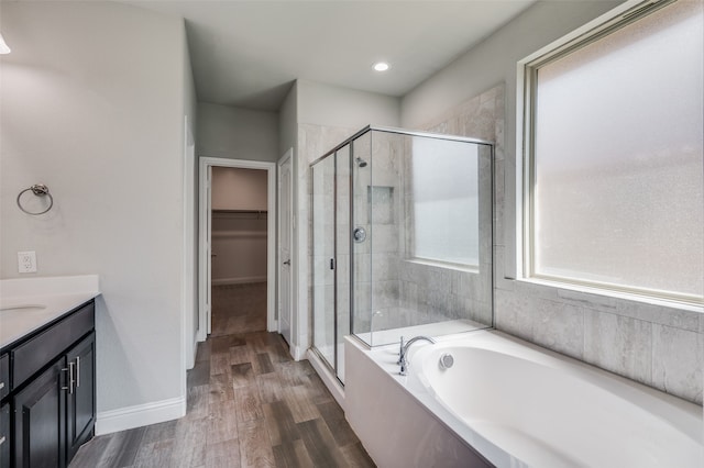 bathroom featuring hardwood / wood-style floors, vanity, and separate shower and tub