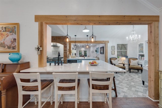 kitchen featuring built in shelves, decorative light fixtures, light hardwood / wood-style floors, kitchen peninsula, and a breakfast bar area