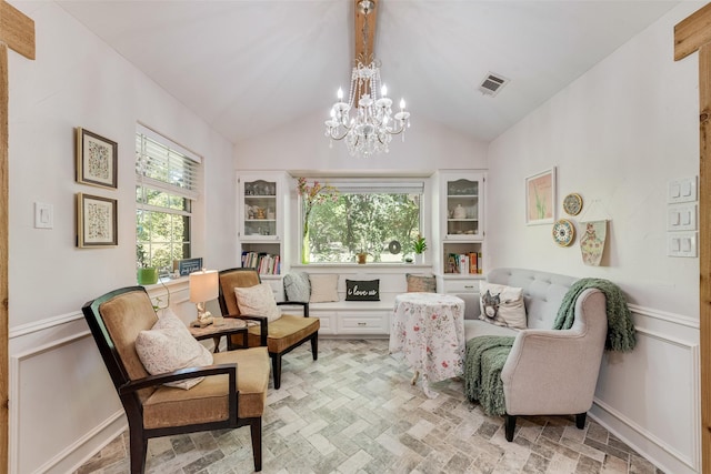 sitting room with vaulted ceiling and an inviting chandelier