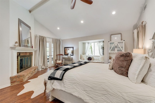 bedroom featuring hardwood / wood-style floors, high vaulted ceiling, ceiling fan, a fireplace, and beam ceiling