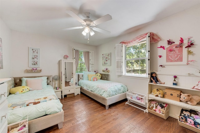 bedroom with multiple windows, hardwood / wood-style flooring, and ceiling fan