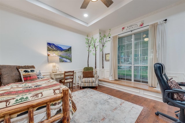 bedroom featuring hardwood / wood-style floors, a raised ceiling, and ceiling fan