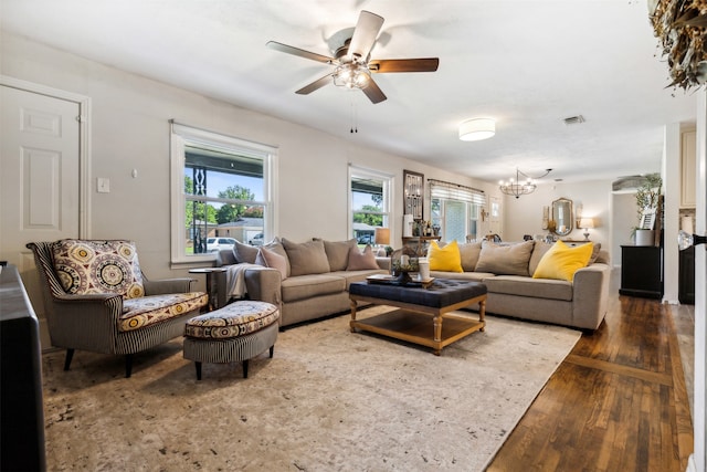 living room featuring dark hardwood / wood-style flooring and ceiling fan with notable chandelier