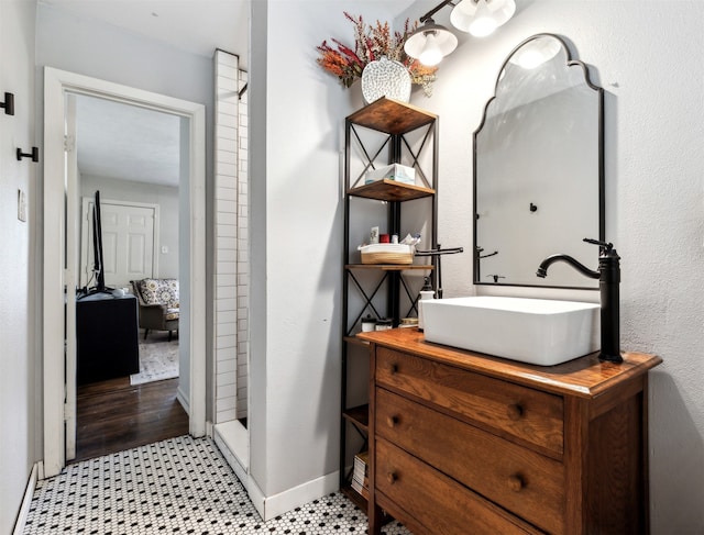 bathroom featuring hardwood / wood-style floors, walk in shower, and vanity