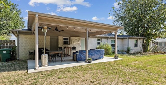 rear view of property with a patio area, a lawn, and ceiling fan