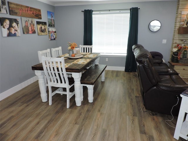 dining space featuring ornamental molding and hardwood / wood-style flooring