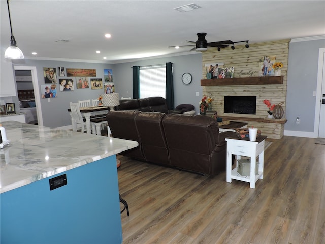 living room featuring crown molding, ceiling fan, a fireplace, and dark hardwood / wood-style flooring